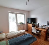 1 izbový byt na predaj rekonštrukcia, Martin centrum, nový balkón - Spálňová zóna v 1-izbovom byte s podlahou s dreveným dekorom a pracovným stolom.