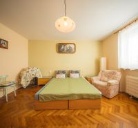 NA PREDAJ RODINNÝ DOM PO REKONŤRUKCII _GOLIANOVO - Spálňa v rodinnom dome s posteľou, kreslom a podlahou s dreveným dekorom.