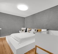Na predaj nádherný 4 izbový luxusný byt,176 m2 + terasy 55 m2,2 garáž. - Spálňa v 4-izbovom byte s podlahou s dreveným dekorom a šedou stenou.