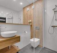 Na predaj nádherný 4 izbový luxusný byt,176 m2 + terasy 55 m2,2 garáž. - Kúpeľňa 4-izbového bytu s podlahou s dreveným dekorom a sprchovým kútom.