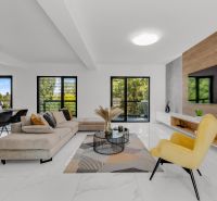Na predaj nádherný 4 izbový luxusný byt,176 m2 + terasy 55 m2,2 garáž. - Otvárajúca obývacia izba s pohodlnou sedačkou, žltým kreslom a TV na stene.