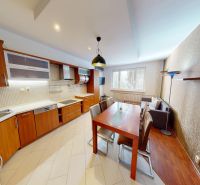 VÝHODNÁ PONUKA!!! (65 m²) 3i BYT S LOGGIOU V SRDCI SÍDLISKA KVP - Kuchyňa 3-izbového bytu s dreveným dekorom, jedálenským stolom a pohovkou.