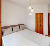 VÝHODNÁ PONUKA!!! (65 m²) 3i BYT S LOGGIOU V SRDCI SÍDLISKA KVP - Spálňa v 3-izbovom byte s posteľou, skriňou a podlahou s dreveným dekorom.