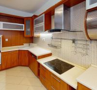 VÝHODNÁ PONUKA!!! (65 m²) 3i BYT S LOGGIOU V SRDCI SÍDLISKA KVP - Kuchyňa v 3-izbovom byte s dreveným dekorom kuchynskej linky a sklenými skrinkami.