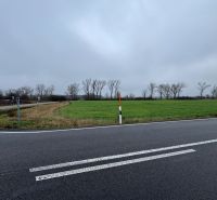 Priemyselné pozemky | 5722 m² + Bonus 2464  | Malacky - Pozemky - komerčné v Záhorskej Vsi: zelené pole pri ceste, stromy v diaľke, zamračené.