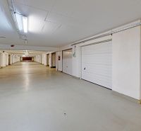 Samostatná uzatvorená garáž-sklad na diaľkové ovládanie, Šustekova - Krytá garáž so sekčnými bránami, bielym stropom a osvetlením.