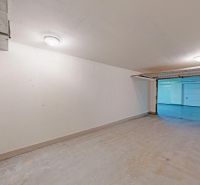 Samostatná uzatvorená garáž-sklad na diaľkové ovládanie, Šustekova - Priestranné garáže s bielymi stenami a garážovou bránou v Bratislava - Petržalka.