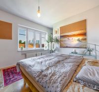 Prenájom | 2-izbový byt | Záhradnícka – Poľská ulica | 900 € + 200 € e - Spálňa v 2-izbovom byte s obrazom na stene a podlahou s dreveným dekorom.