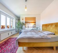 Prenájom | 2-izbový byt | Záhradnícka – Poľská ulica | 900 € + 200 € e - Svetlá spálňa s posteľou a podlahou s dreveným dekorom v 2-izbovom byte.