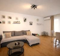 Vodice(HR)-Kompletne zariadený 3 izbový apartmán - Pohodlný obývací priestor v rekreačnom apartmáne s podlahou s dreveným dekorom a jedálenským stolom.
