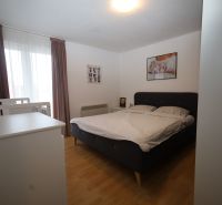 Vodice(HR)-Kompletne zariadený 3 izbový apartmán - Spálňa s posteľou a detskou postieľkou v Rekreačnom apartmáne, podlaha s dreveným dekorom.