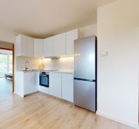 | Pekný a priestranný 3-izbový byt | 70m² |  - Kuchyňa s bielou linkou, vstavanými spotrebičmi a podlahou s dreveným dekorom v 3-izbovom byte.