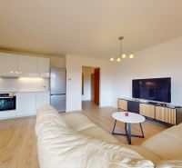| Pekný a priestranný 3-izbový byt | 70m² |  - Obývacia izba s podlahou s dreveným dekorom, kuchyňou, sedačkou a televízorom v 3-izbovom byte.