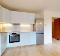 | Pekný a priestranný 3-izbový byt | 70m² |  - Kuchyňa v 3-izbovom byte s bielymi skrinkami a podlahou s dreveným dekorom.