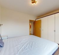 | Pekný a priestranný 3-izbový byt | 70m² |  - Spálňa s veľkou šatníkovou skriňou, posteľou a umením v 3-izbovom byte.