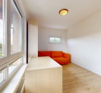 | Pekný a priestranný 3-izbový byt | 70m² |  - Izba s oranžovou sedačkou, veľkým oknom a podlahou s dreveným dekorom v 3-izbovom byte.