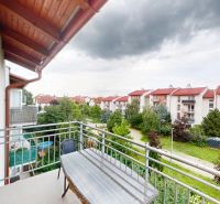 | Pekný a priestranný 3-izbový byt | 70m² |  - Balkón z 3-izbového bytu s výhľadom na zeleň a okolité budovy v Devínskej Novej Vsi.