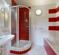 | Pekný a priestranný 3-izbový byt | 70m² |  - Kúpeľňa v 3-izbovom byte s vaňou, sprchovacím kútom a červenými obkladmi.