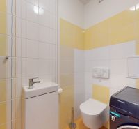 | Pekný a priestranný 3-izbový byt | 70m² |  - Kúpeľňa s práčkou v 3-izbovom byte, kombinácia bielych a žltých obkladov.