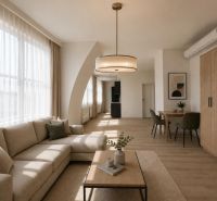 VÝNIMOČNÝ SLNEČNÝ APARTMÁN v centre mesta, UNO Poštová - Obývacia izba s pohovkou, stolom a podlahou s dreveným dekorom v 1-izbovom byte.