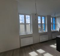 VÝNIMOČNÝ SLNEČNÝ APARTMÁN v centre mesta, UNO Poštová - Svietlá miestnosť s tromi oknami a podlahou s dreveným dekorom v 1-izbovom byte.