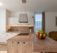Moderný 2-izbový apartmán s parkovaním, Vila Leonardo, Bajkalská - Kuchyňa s ostrovčekom a ovocím v 2-izbovom byte, podlaha s dreveným dekorom.