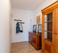Moderný 2-izbový apartmán s parkovaním, Vila Leonardo, Bajkalská - Interiér 2-izbového bytu s dreveným nábytkom a podlahou s dreveným dekorom.