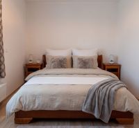 Moderný 2-izbový apartmán s parkovaním, Vila Leonardo, Bajkalská - Spálňa s lôžkom a dreveným nábytkom v 2-izbovom byte, podlaha s dreveným dekorom.