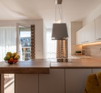 Moderný 2-izbový apartmán s parkovaním, Vila Leonardo, Bajkalská - Kuchyňa v 2-izbovom byte s otvoreným balkónom a dekorom drevenej podlahy.