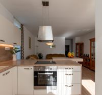 Moderný 2-izbový apartmán s parkovaním, Vila Leonardo, Bajkalská - Kuchyňa v 2-izbovom byte s podlahou s dreveným dekorom a bielymi skrinkami.