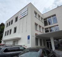 Ponúkame najlacnejšie  kancelárske priestory v Prievidzi  - Budova kancelárií na Dlhej ulici v Prievidzi so zaparkovanými autami.