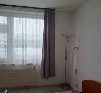 Predaj 2-izbového bytu, T. Vansovej, T. Vansovej, Nové Zámky - Izba s posteľou, oknami a podlahou s dreveným dekorom v 2-izbovom byte.