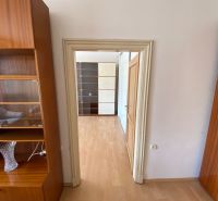 Byt na rekonštrukciu v centre Bratislavy – výborný projekt - Interiér 2-izbového bytu s podlahou s dreveným dekorom a dreveným nábytkom.