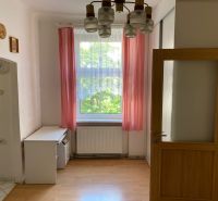 Byt na rekonštrukciu v centre Bratislavy – výborný projekt - Izba s podlahou s dreveným dekorom a ružovými závesmi v 2-izbovom byte.