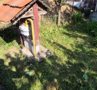 Na predaj vidiecky dom v Dedinke 3+1 s pozemkom 3150m2  - Záhrada rodinného domu v Dedinke s trávnikom, plynomerom a kôpkou zeme v pozadí.