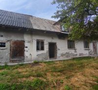 Kamenný vidiecky dom v obci Čelovce okres Veľký Krtíš. - Rodinný dom v Čelovciach s opotrebovanou omietkou, drevenými dverami a záhradou.