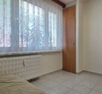 Na predaj 2 izbový byt Zvolen, 64 m2 - Interiér 2-izbového bytu s kachličkovými dverami, sedačkou a oknom s čipkovanou záclonou.