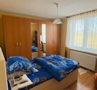 PREDAJ - Rodinný dom s veľkým pozemkom – Nitra, Lužianky  - Spálňa v rodinnom dome s drevenou skriňou a modrými posteľnými obliečkami.