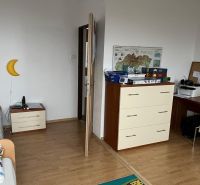 Rodinný dom v Štitároch s výhľadom a pod lesom - Izba v rodinnom dome s posteľou, komodou, stolom a podlahou s dreveným dekorom.