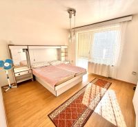Rodinný dom s pivnicou, garážou a záhradou – Závod - Spálňa v rodinnom dome s posteľou, ventilátorom a podlahou s dreveným dekorom.