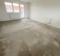 Na predaj 3 izb. byt s balkónom blízko centra - Prázdna miestnosť v 3-izbovom byte so základnou podlahou a bielymi stenami.
