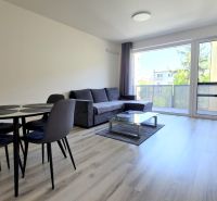 MODERNÝ 2i byt, POD VINICOU, LOGGIA, PARKING, Nové Mesto - Svetlá obývacia izba v 2-izbovom byte s kobercovým dekorom a balkónom.