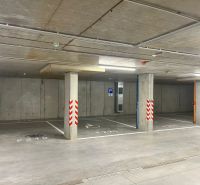 Prenájom kancelárskych / obchodných priestorov s terasou - Podzemné parkovacie miesta v kanceláriách v Považskej Bystrici, betónové steny a podlaha.