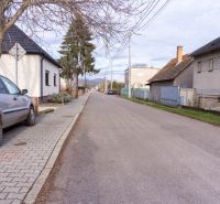 NA PREDAJ pozemky na výstavbu - Ulica s rodinnými domami na Športovej ul. a parkované auto, ideálne pre Pozemky - bývanie.