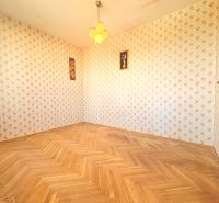 Na predaj: CENTRUM: 3 izb.byt + ŠATNIK + PIVNICA - Izba s retro tapetou a podlahou s dreveným dekorom v 3-izbovom byte.