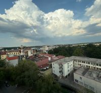 Na predaj: CENTRUM: 3 izb.byt + ŠATNIK + PIVNICA - Panoráma Levic s výhľadom na budovy a oblačnú oblohu v pozadí.