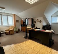 NA PREDAJ rodinný dom/polyfunkcia Komjatice  - Interiér kancelárie s pracovným stolom, pohodlnými kreslami a podlahou vhodnou pre rodinný dom.