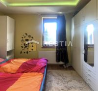 ZNÍŽENÁ CENA Bungalov s veľkým potenciálom Borský Mikuláš - Spálňa v rodinnom dome s nástennými dekoráciami a farebnými prikrývkami.