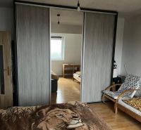 Rodinný dom v Štitároch s výhľadom a pod lesom - Spálňa v rodinnom dome s posteľou, vstavanou skriňou a podlahou s dreveným dekorom.