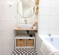 ŠTÝLOVÝ 2i BYT, REKONŠTRUKCIA, BALKÓN, KLÍMA, Murgašová ulica - Kúpeľňa so zlatým kohútikom, okrúhlym zrkadlom a úložnými košmi v 2-izbovom byte.